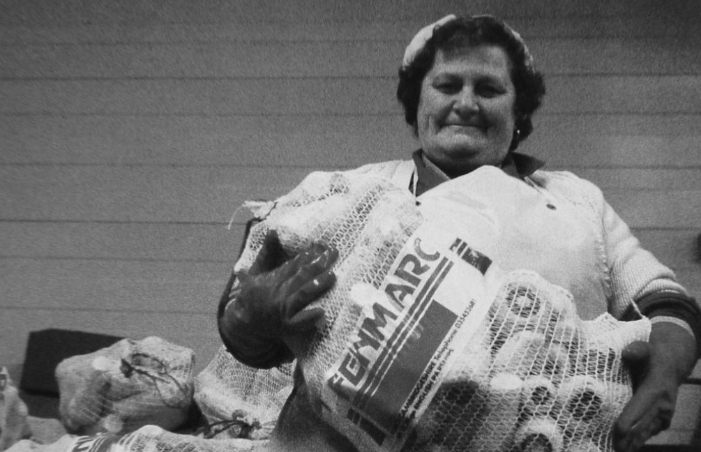 Vintage black and white photo of a woman with a sack of parsnips