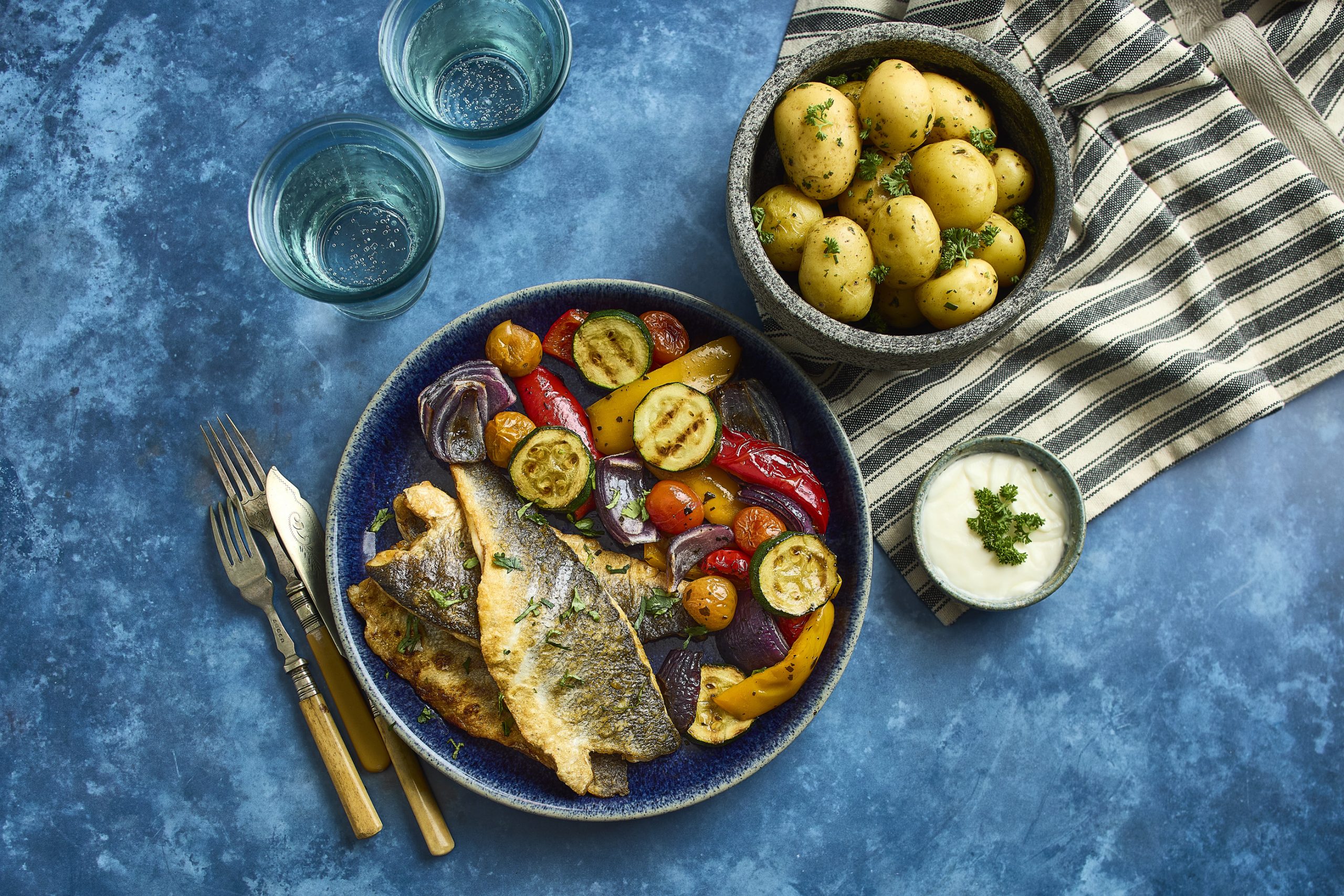 Grilled fish served with a selection of prepared vegetables