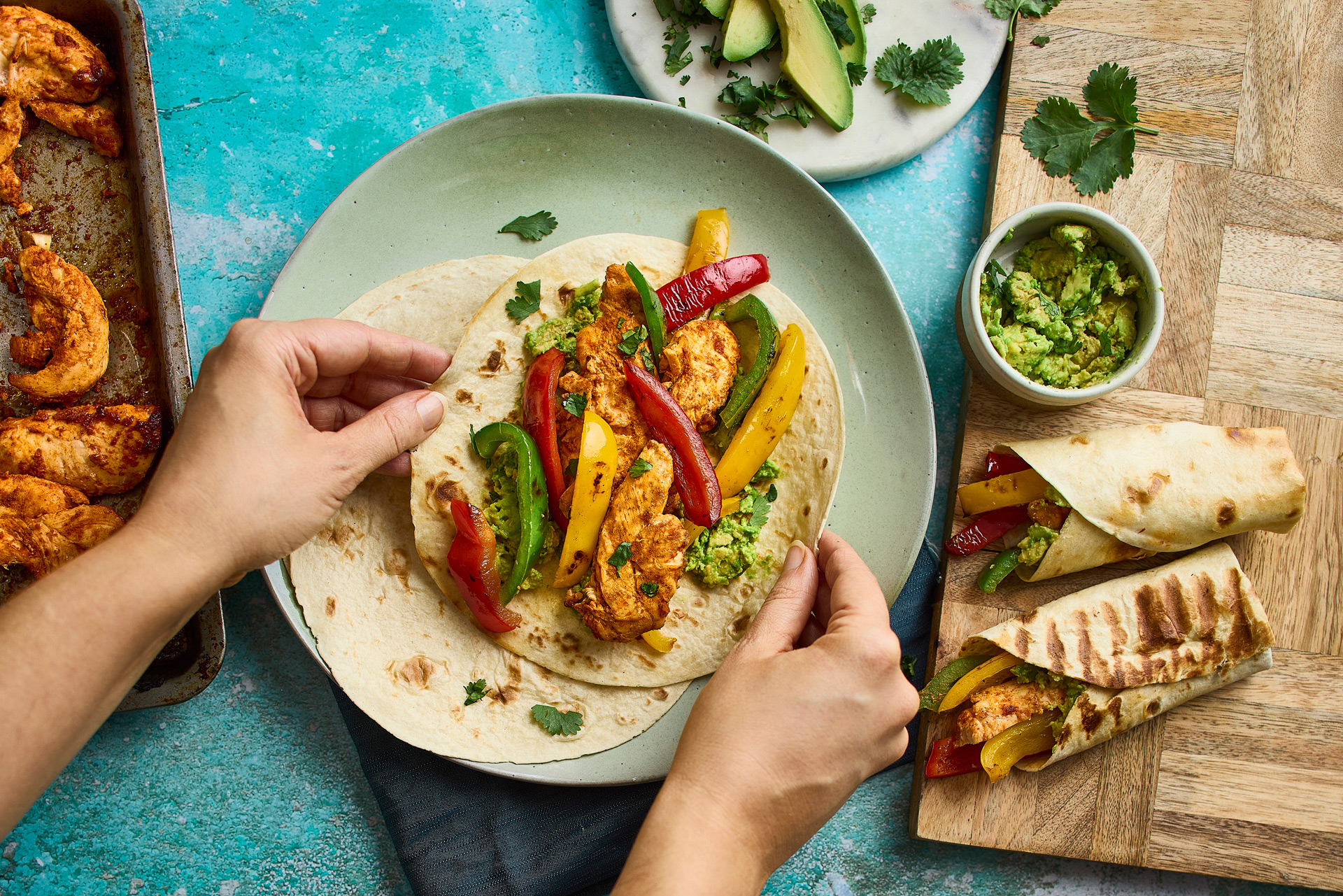 Someone serving a vegetable wrap, with various other vegetable dishes on the table