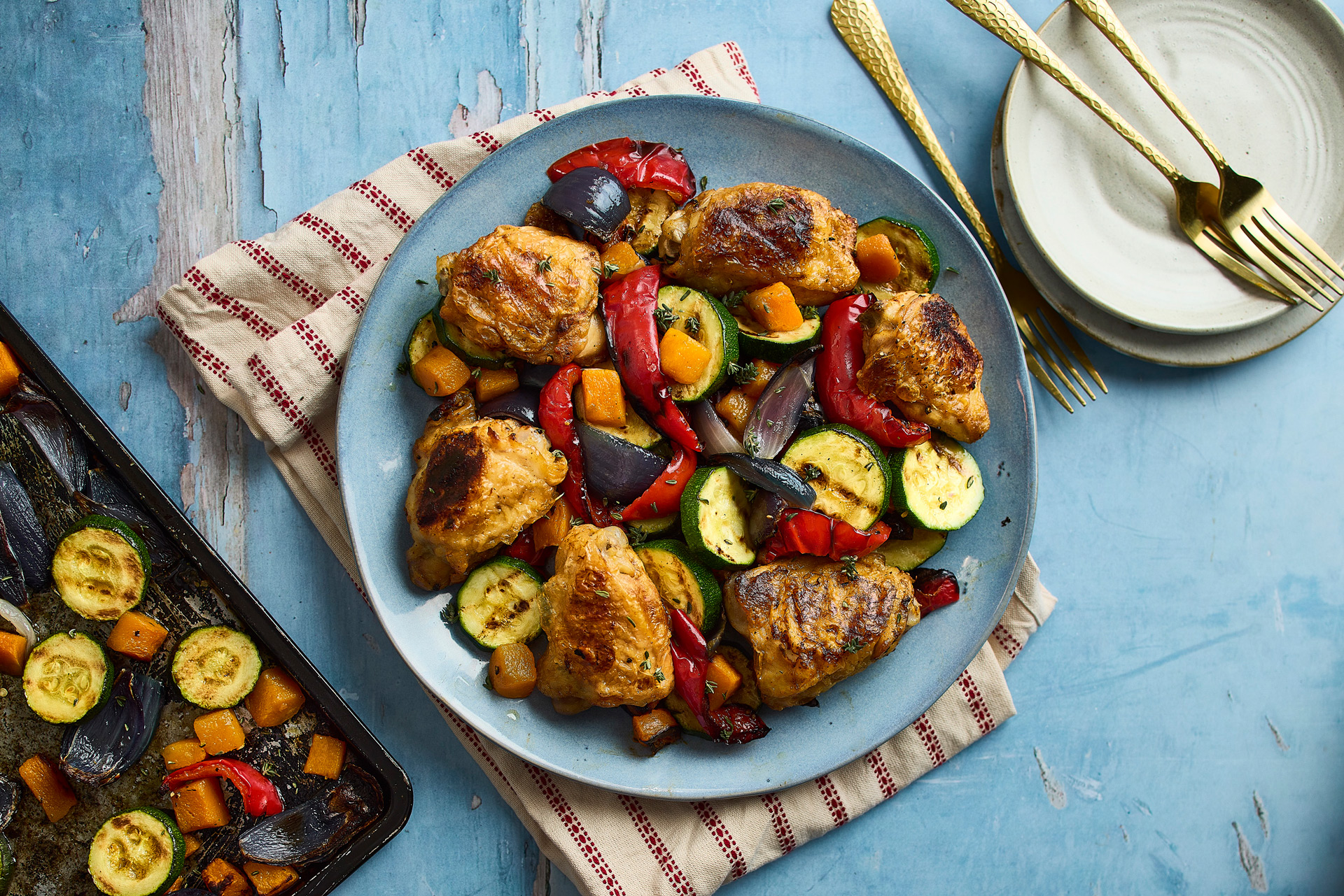 A beautiful plate of roast vegetables, with side plate and forks